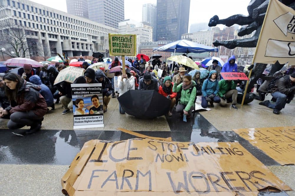 Demonstrators kneel for a moment of silence outside the JFK Federal Building, Monday, March 27, 2017, in Boston, as they protest the detention by federal immigration officials of two advocates for Vermont dairy farm workers, as well as an undocumented Vermont farm worker. (Elise Amendola/AP)