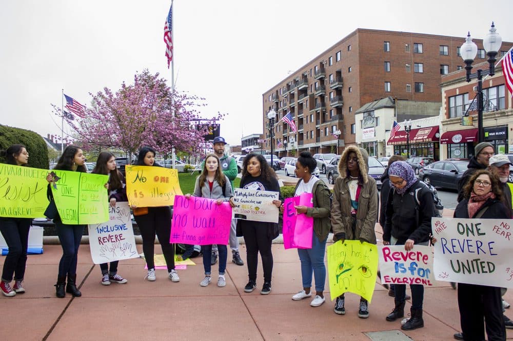 Protesters on May 1 hold signs outside Revere City Hall to express solidarity with the city's immigrants. (Simón Rios/WBUR)