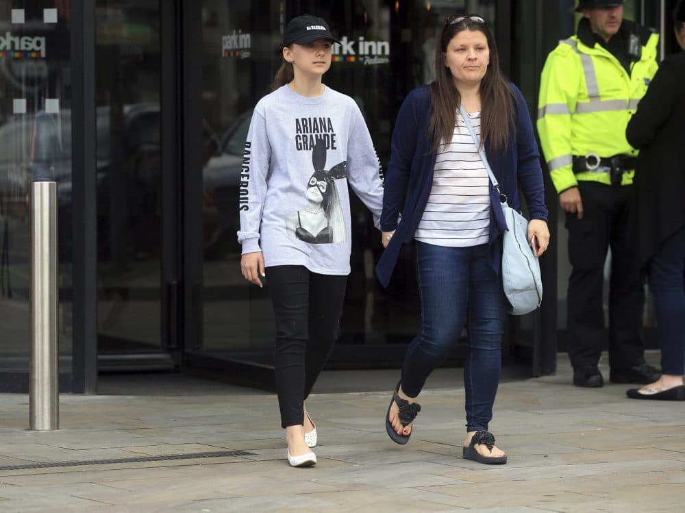 Mother Amy Trippitt and her daughter Grace, who attended the concert in Manchester, Britain, Tuesday May 23, 2017, a day after an explosion. An apparent suicide bomber set off an improvised explosive device that killed over a dozen people at the end of an Ariana Grande concert, Manchester police said Tuesday. (Danny Lawson/PA via AP)