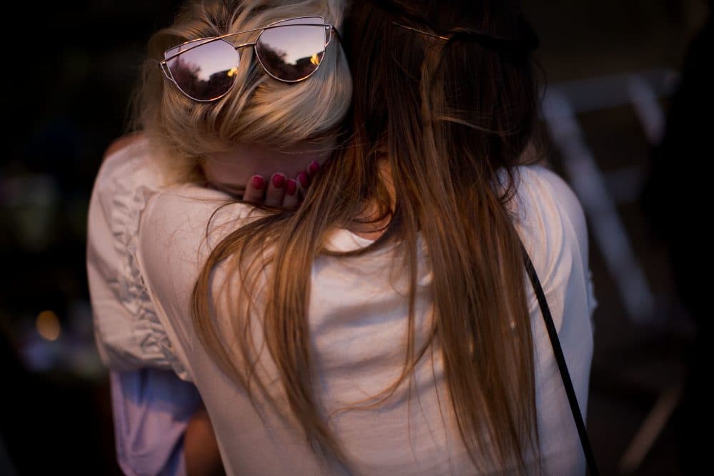 In good times and in bad, writes Joanna Weiss, we find meaning in the rarity of togetherness. In this photo, people cry after a vigil in Albert Square, Manchester, England, Tuesday May 23, 2017, the day after the suicide attack at an Ariana Grande concert that left 22 people dead as it ended on Monday night. (Emilio Morenatti/ AP)