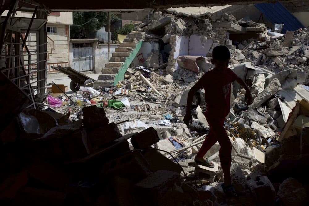 In this Friday, May 26, 2017 file photo, a child plays among the ruins of a house in western Mosul that was destroyed in a March 17 coalition airstrike that killed more than 100 people. (Balint Szlanko, File/AP)