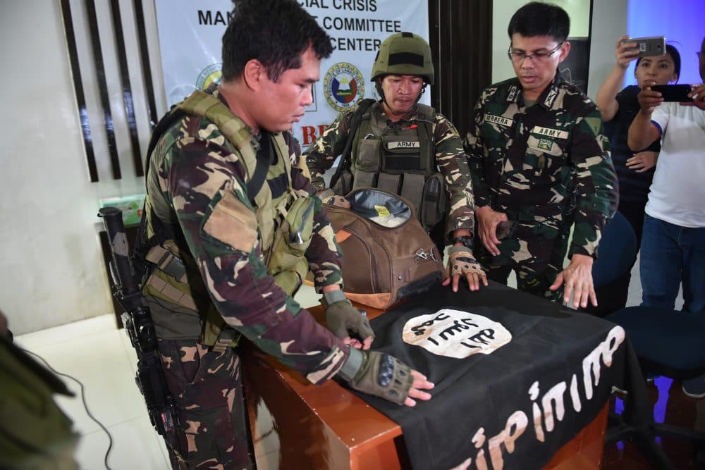 Philippine Army troopers prepare to display an ISIS flag and 11 kilograms of the illegal drug "shabu," which were recovered from an Islamist militants position, prior to a press conference at the provincial capitol in Marawi on the southern island of Mindanao on June 19, 2017. (Ted Aljibe/AFP/Getty Images)
