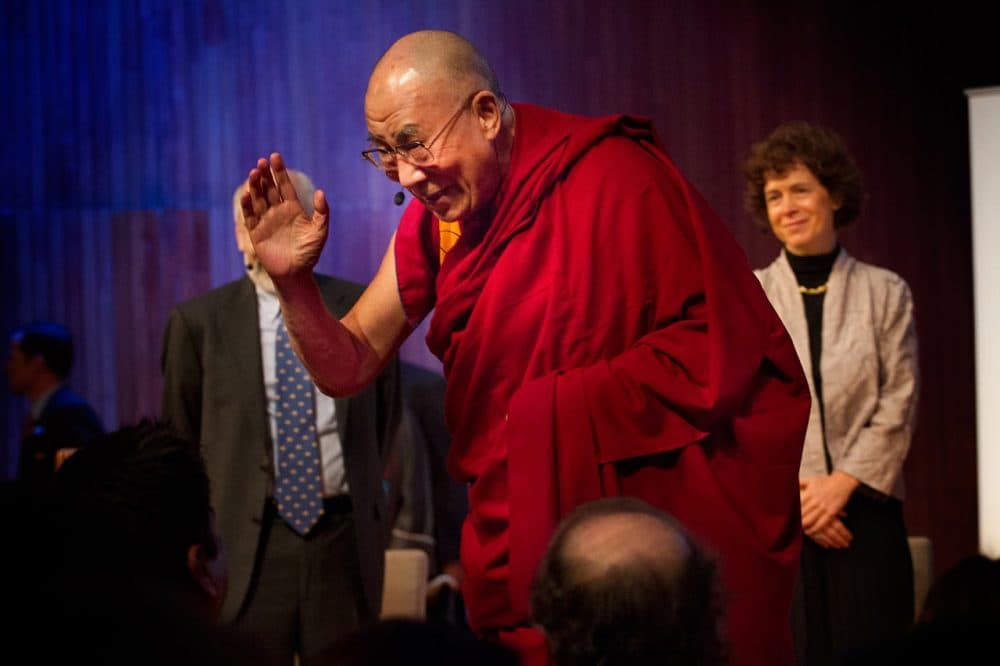 Tibetan exiled spiritual leader the Dalai Lama waves as he takes the stage for the "Ethics, Economy and Environment Panel" at the Global Systems 2.0 Conference at MIT on October 15, 2012. (Jesse Costa/WBUR)