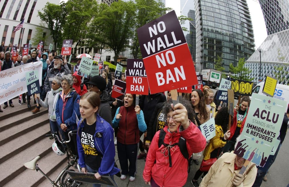 Protesters in Seattle wave signs and chant during a May demonstration against President Trump's travel ban. (Ted S. Warren/AP)