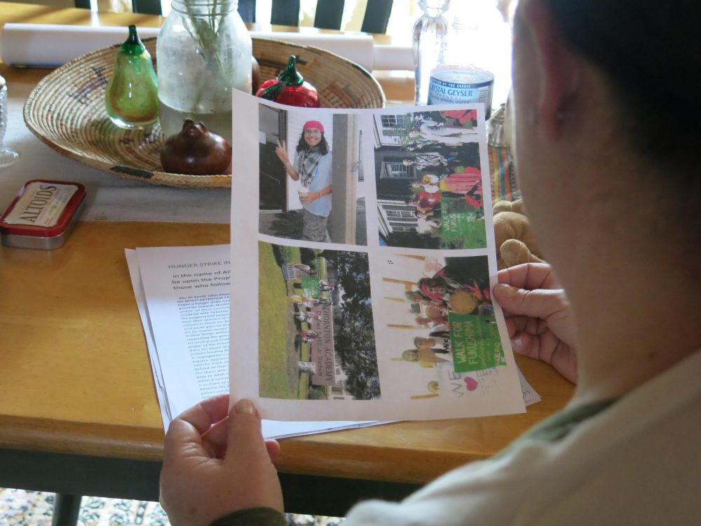 Shelley MacInnes holds pictures of her son, Alex Ciccolo, who faces domestic terrorism charges. (Jill Kaufman/NEPR)