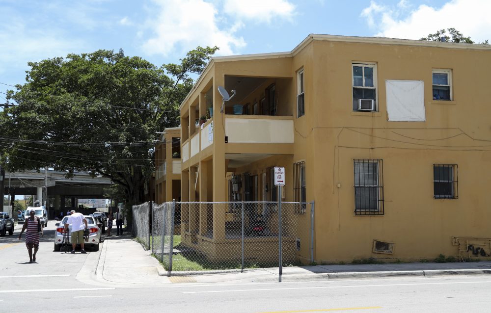 People stand in front of an apartment building where a 10-year-old boy that died of a fentanyl overdose last month lived, in Miami, Fla., Tuesday, July 18, 2017. (Mario Houben/AP)