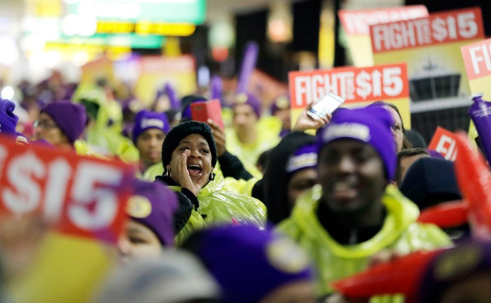 A woman shouts while marching with service workers asking for $15 minimum wage pay during a rally at Newark Liberty International Airport in November. (Julio Cortez/AP)