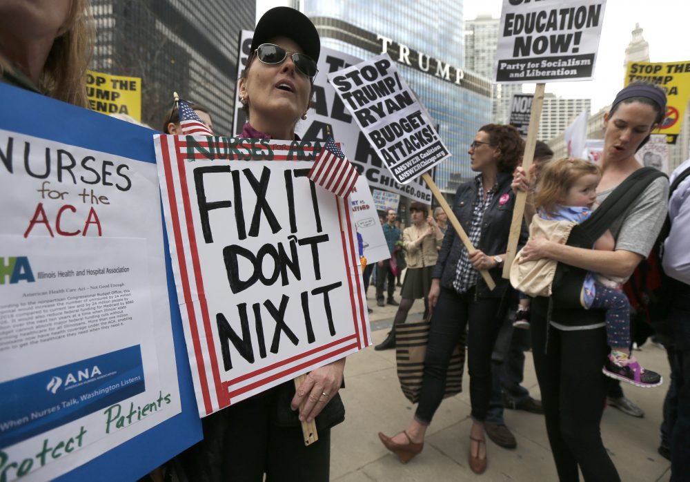 Protesters gather across the Chicago River from Trump Tower to rally against the repeal of the Affordable Care Act Friday, March 24, 2017, in Chicago. (Charles Rex Arbogast/AP)