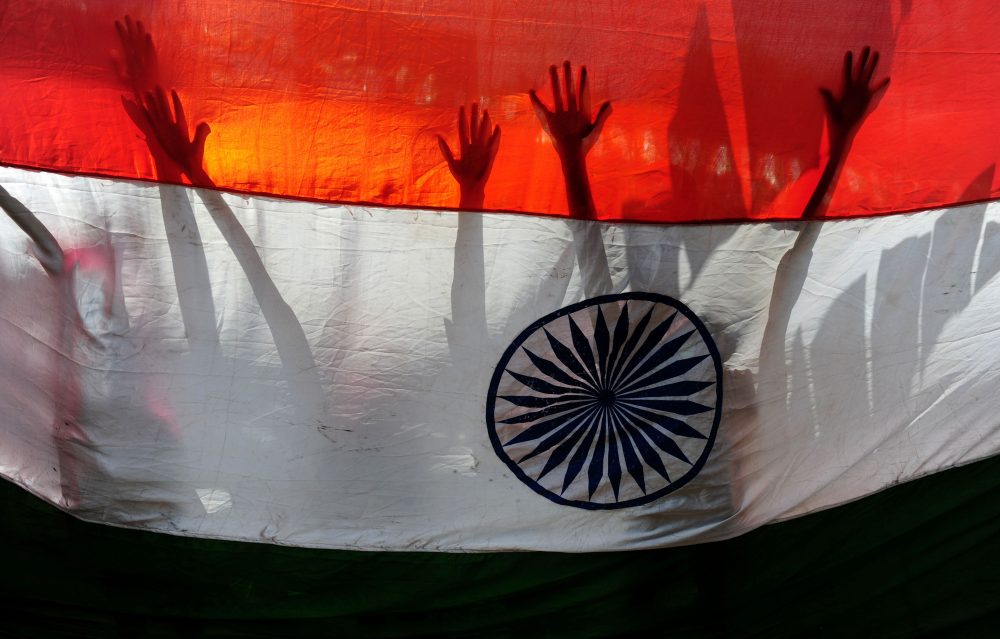 Indian schoolchildren are silhouetted against a national flag as they participate in Independence Day celebrations in Chennai on Aug. 15, 2016. (Arun Sankar/AFP/Getty Images)