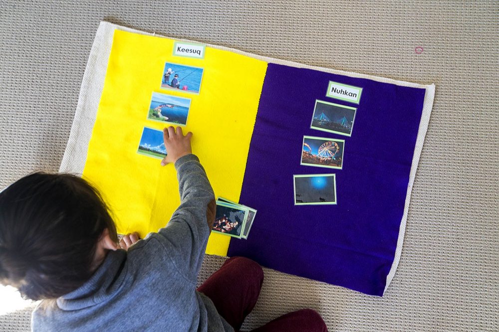 A student groups photos of day and night and matches them with the corresponding Wampanoag word on the floor. (Jesse Coista/WBUR)