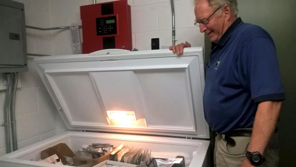 New England Wildflower Society's Bill Brumback, opening the freezer that acts as the "seed vault," in Framingham, Mass. (Jill Kaufman/NEPR)
