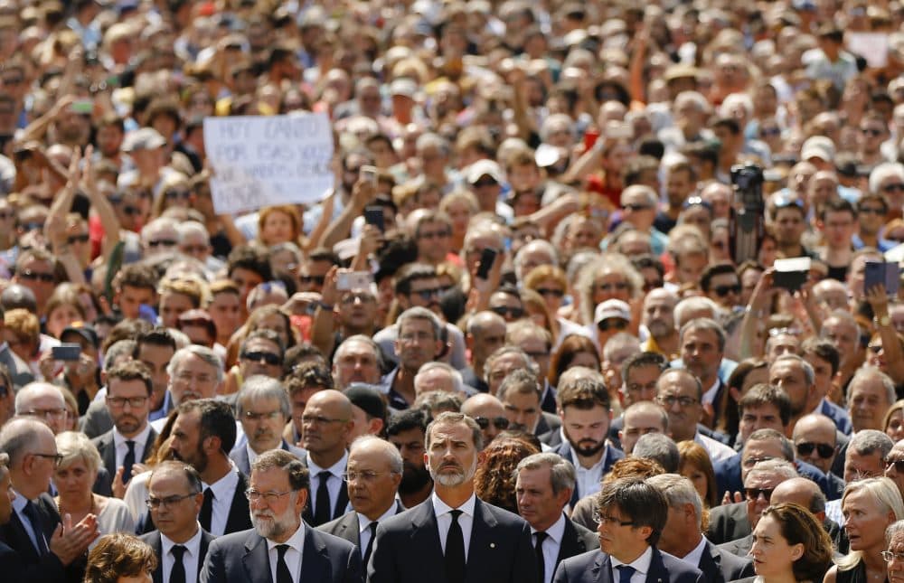 King Felipe of Spain, center, Prime Minister Mariano Rajoy, center left, and and Catalonia regional President Carles Puigdemont, center right, join people observing a minute of silence in memory of the terrorist attacks victims Friday. (Francisco Seco/AP)