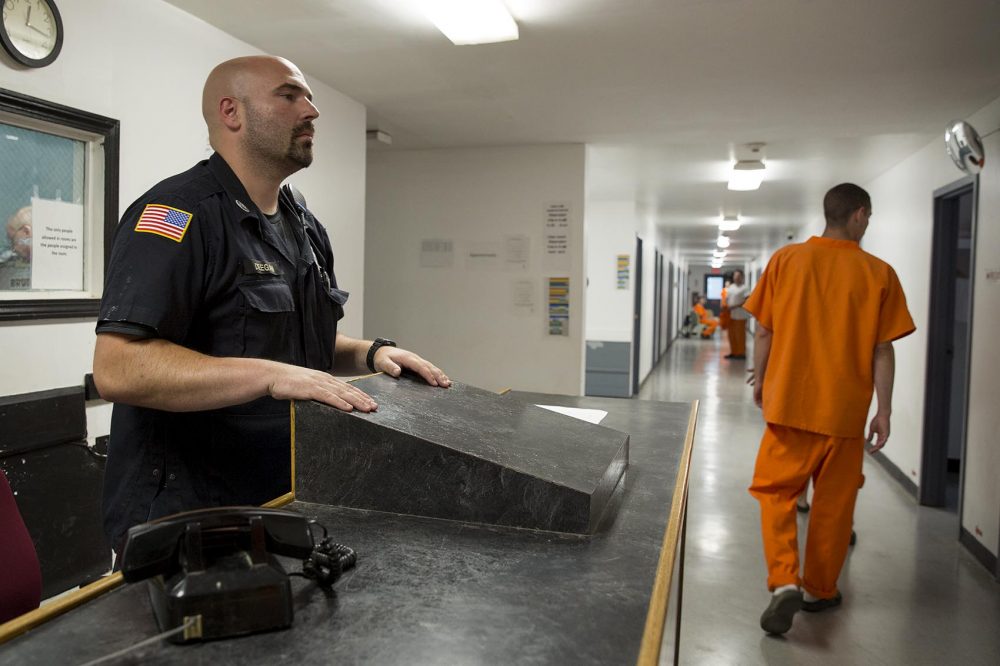 Corrections Officer Christopher Deegan oversees a corridor in MASAC at Plymouth, as patients walk around. (Robin Lubbock/WBUR)