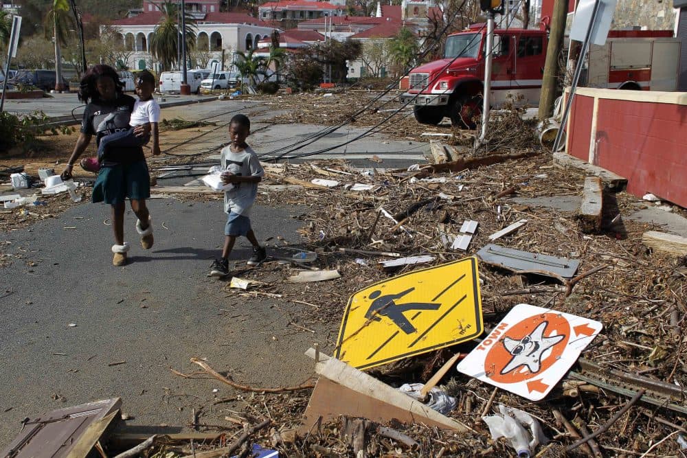 A woman with her two children walk past debris left by Hurricane Irma in Charlotte Amalie, St. Thomas, U.S. Virgin Islands, Sunday, Sept. 10, 2017. (Ricardo Arduengo/AP)