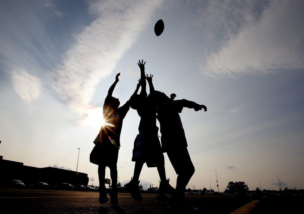 Kids play football in the parking lot before an NFL preseason football game between the New England Patriots and the New York Giants, Thursday, Aug. 31, 2017, in Foxborough, Mass. (Winslow Townson/AP)