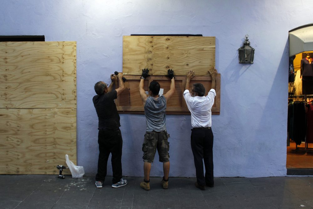 People board up windows of a business in preparation for the anticipated arrival of Hurricane Maria in San Juan, Puerto Rico on Sept. 18, 2017. Hurricane Maria has grown into a maximum-strength Category 5 storm, US forecasters said Monday, as it was bearing down on the Caribbean island of Dominica. (Ricardo Arduengo/AFP/Getty Images)