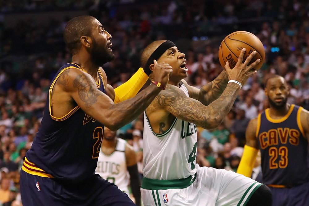 Isaiah Thomas, formerly of the Boston Celtics, drives to the basket against Kyrie Irving, formerly of the Cleveland Cavaliers, in the 2017 NBA playoffs. The players have swapped jerseys after a recent blockbuster trade. (Elsa/Getty Images)