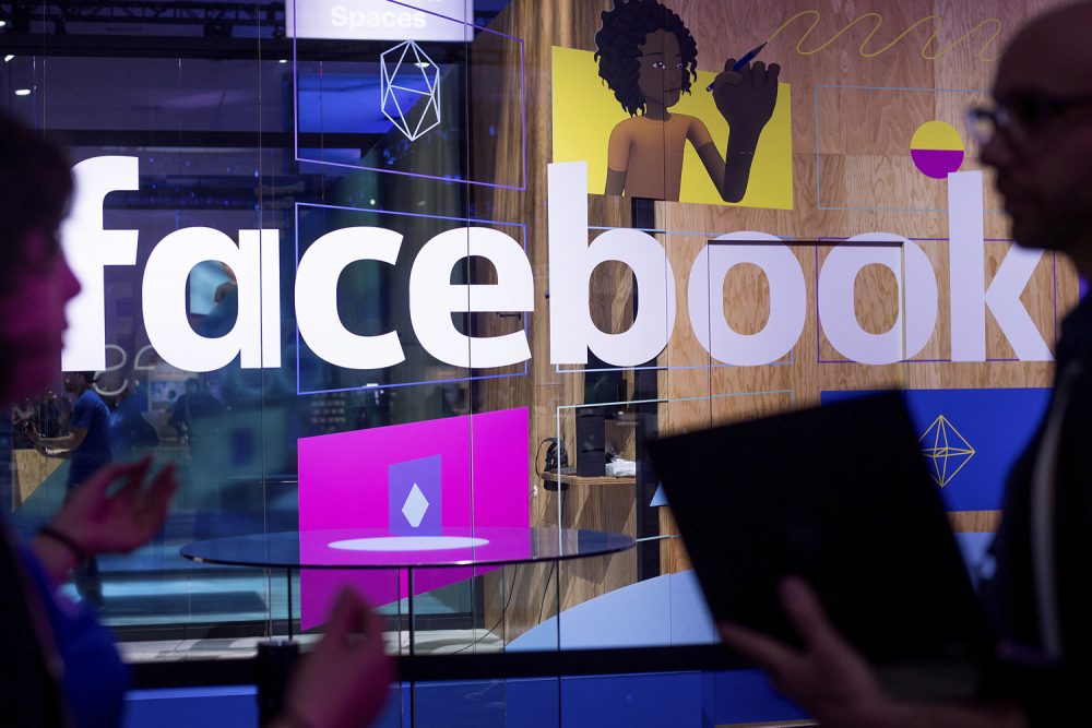 In this April 18, 2017 photo, conference workers speak in front of a demo booth at Facebook's annual F8 developer conference in San Jose, Calif. (Noah Berger/AP)