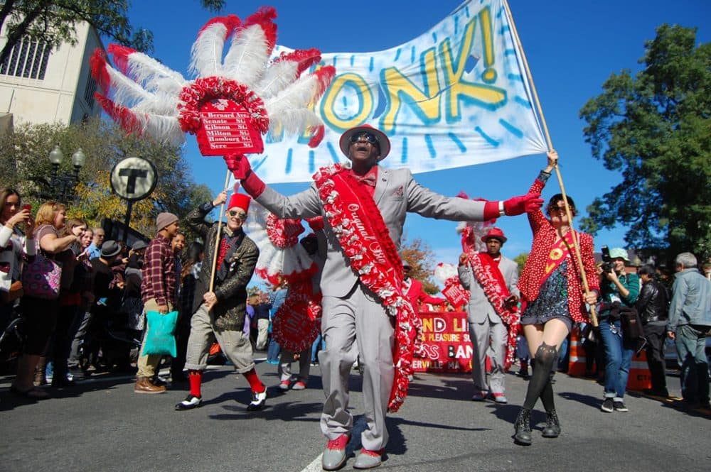 A member of the Original Big Seven Social Aid and Pleasure Club from New Orleans dances near the front of the HIONK! Parade on Sunday, Oct. 11, 2015. (Greg Cook/WBUR)