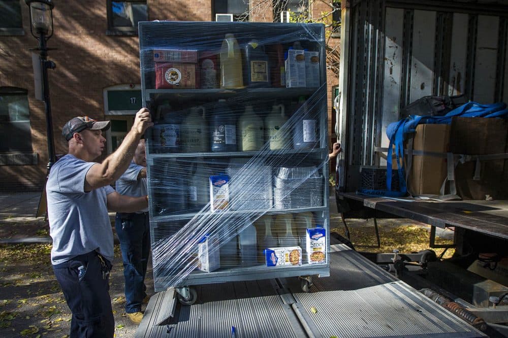 A mover loading shelves of various ingredients from America's Test Kitchen onto a moving truck in Brookline Village on Oct. 4. (Jesse Costa/WBUR)