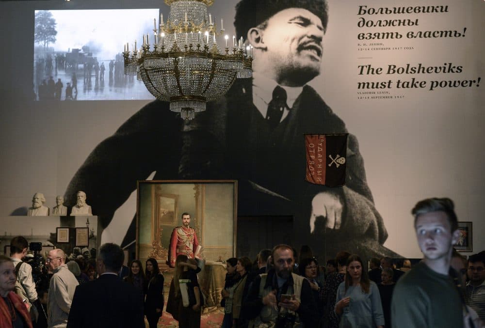 People gather by a portrait of the last Russian tsar Nicholas II and a huge image of the Soviet Union founder Vladimir Lenin during the opening of the exhibition entitled "The Winter Palace and the Hermitage in 1917. History was made here" at the State Hermitage Museum in Saint Petersburg on Oct. 25, 2017. (Olga Maltseva/AFP/Getty Images)