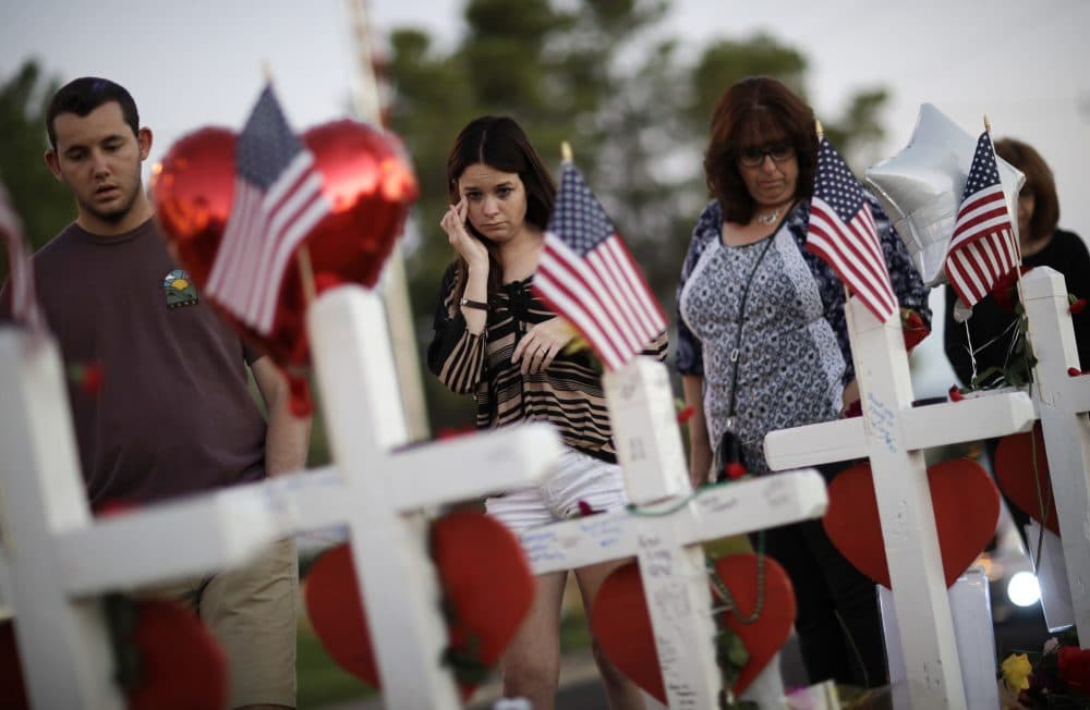 People visit a makeshift memorial Friday, Oct. 6, 2017, for victims of a mass shooting in Las Vegas. Stephen Paddock opened fire on an outdoor music concert on Sunday killing dozens and injuring hundreds. (John Locher/AP)