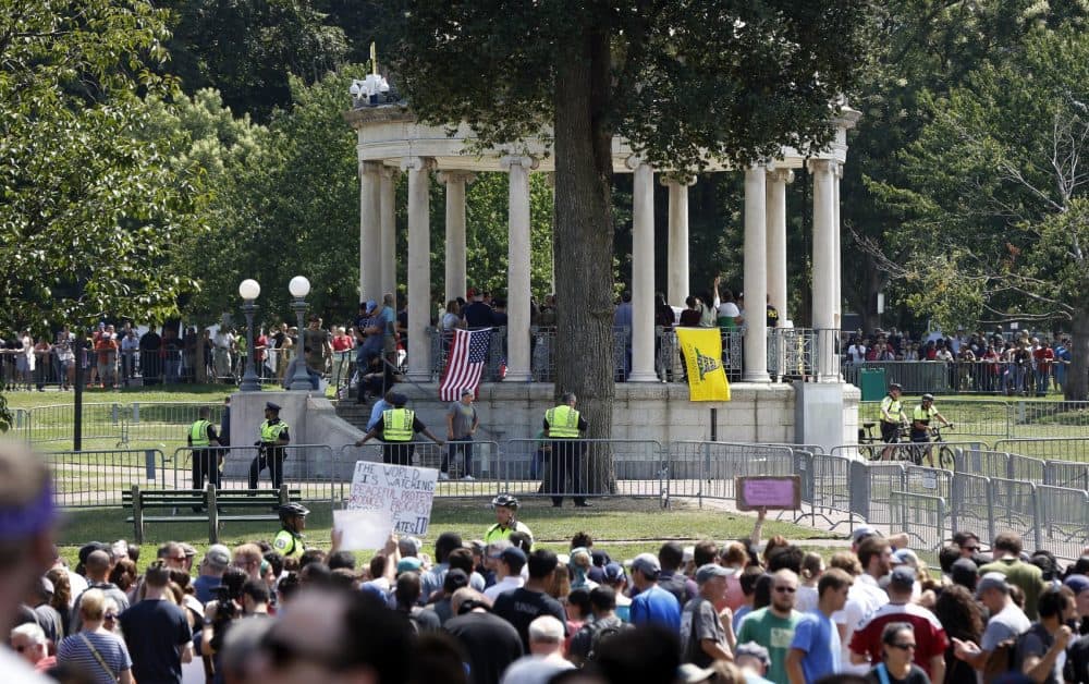 Organizers stand on the bandstand on Boston Common during a self-described "free speech"
rally in August. Throngs of counter-protesters stand along barricades separating them from the rally attendees. (Michael Dwyer/AP)