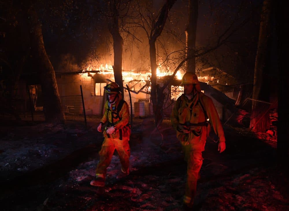 Firefighters move away from a burning house after discovering downed live power lines, as the Thomas wildfire continues to burn in Carpinteria, Calif., on Dec. 10, 2017. (Mark Ralston/AFP/Getty Images)