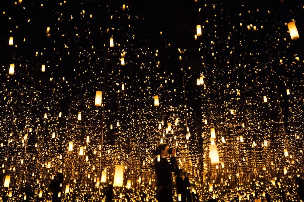 A woman photographs inside the "Aftermath of Obliteration of Eternity" room during a preview of the Yayoi Kusama's "Infinity Mirrors" exhibit at the Hirshhorn Museum on Feb. 21, 2017 in Washington, D.C. (Brendan Smialowski/AFP/Getty Images)