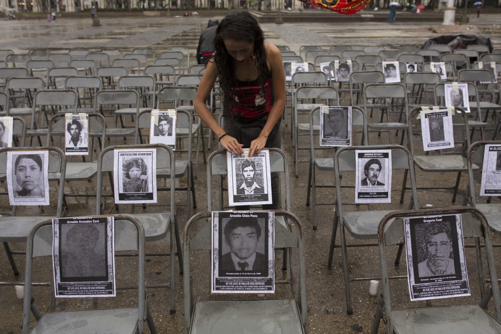 María Meza Paniagua adjunta el retrato de un desaparecido a una silla, en una ceremonia que marca el Día Nacional Contra la Desaparición Forzada, en Guatemala, el 21 de junio de 2017. Según grupos de derechos humanos, más de 40,000 personas fueron "desaparecidas" durante los 36 años del conflicto interno en Guatemala. (Moisés Castillo/AP)