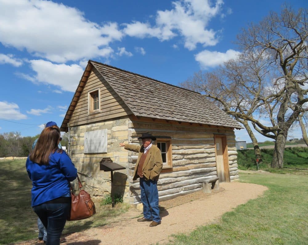El Dean Holthus of Smith Center, Kansas, leads a tour of the property where Brewster Higley wrote 'Home on the Range,' including a restored cabin where Higley lived. (C.J. Janovy/KCUR)