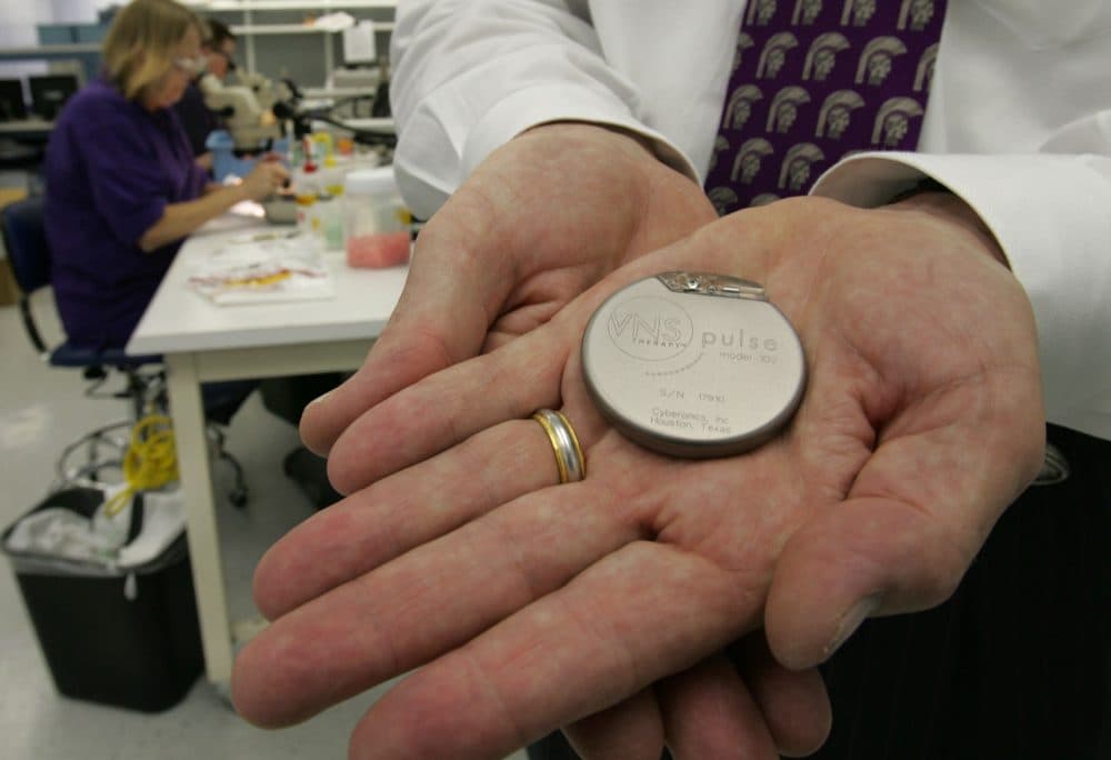 Robert Cummins, CEO and chairman of Cyberonics, holds a vagus nerve stimulator at the companies headquarters in Houston, Tuesday, July 20, 2004. (David J. Phillip/AP)