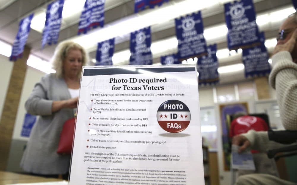 In this March 1, 2016, file photo, a sign tells voters of voter ID requirements before participating in the primary election at Sherrod Elementary school in Arlington, Texas. Attorneys challenging tough voter ID laws in Texas and North Carolina say they’ll keep pressing their lawsuits without the support of President Donald Trump’s Justice Department if necessary. Trump announced Wednesday, Jan. 25, 2017, that he is ordering a “major investigation” into voter fraud, which tough laws requiring photo identification at the ballot box are designed to prevent. (LM Otero/AP)