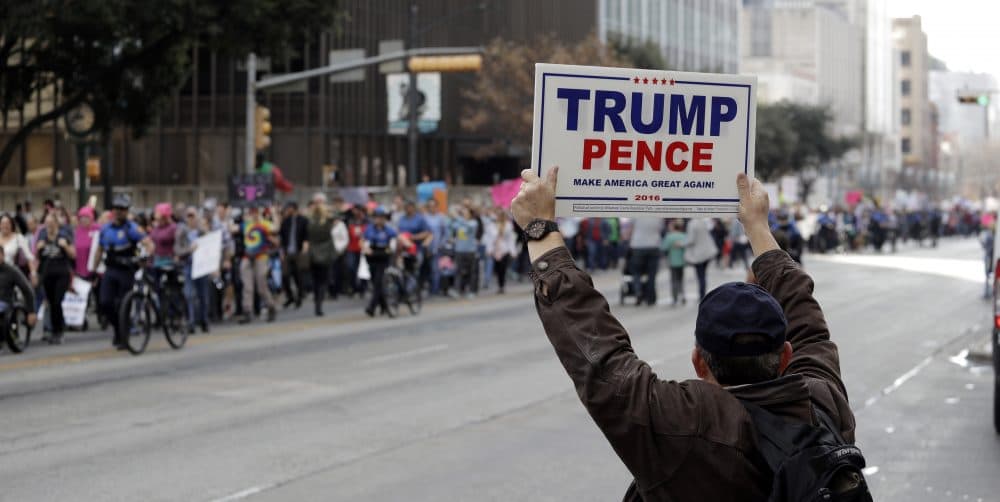 A supporter of President Donald Trump holds a sign as a women's march heading to the Texas State Capitol passes on the one-year anniversary of President Donald Trump's inauguration, Saturday, Jan. 20, 2018, in Austin, Texas. (Eric Gay/AP)