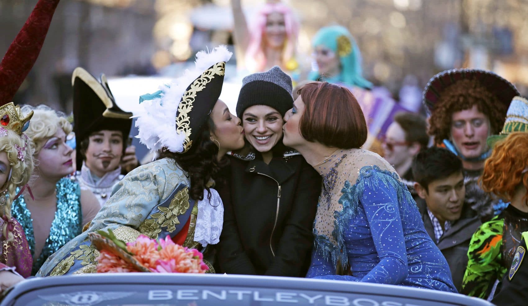 Actress Mila Kunis is kissed by actors dressed in drag during a parade for Kunis in Cambridge, Thursday, Jan. 25, 2018. Kunis was honored as "Woman of the Year" by the Hasty Pudding Theatricals at Harvard University. (Charles Krupa/AP)