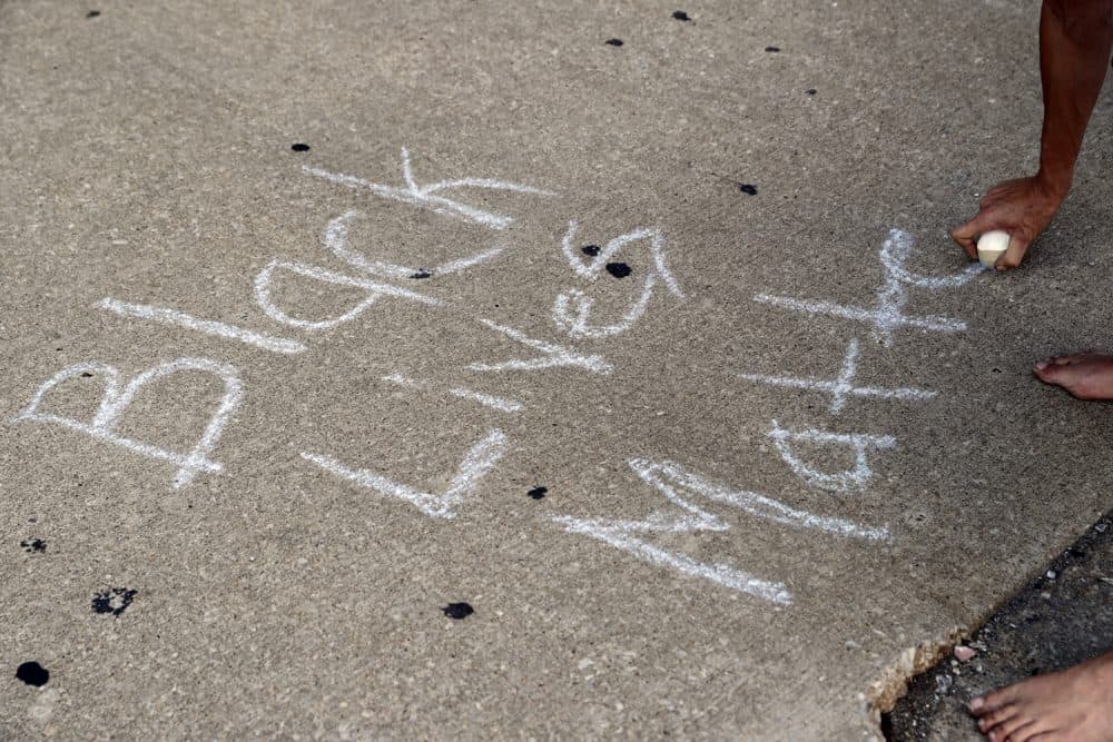 A protester writes, "Black Lives Matter," on the ground with a chalk as protesters gather, Friday, Sept. 15, 2017, in downtown St. Louis, after a judge found a white former St. Louis police officer, Jason Stockley, not guilty of first-degree murder in the death of a black man, Anthony Lamar Smith, who was fatally shot following a high-speed chase in 2011. (AP Photo/Jeff Roberson)