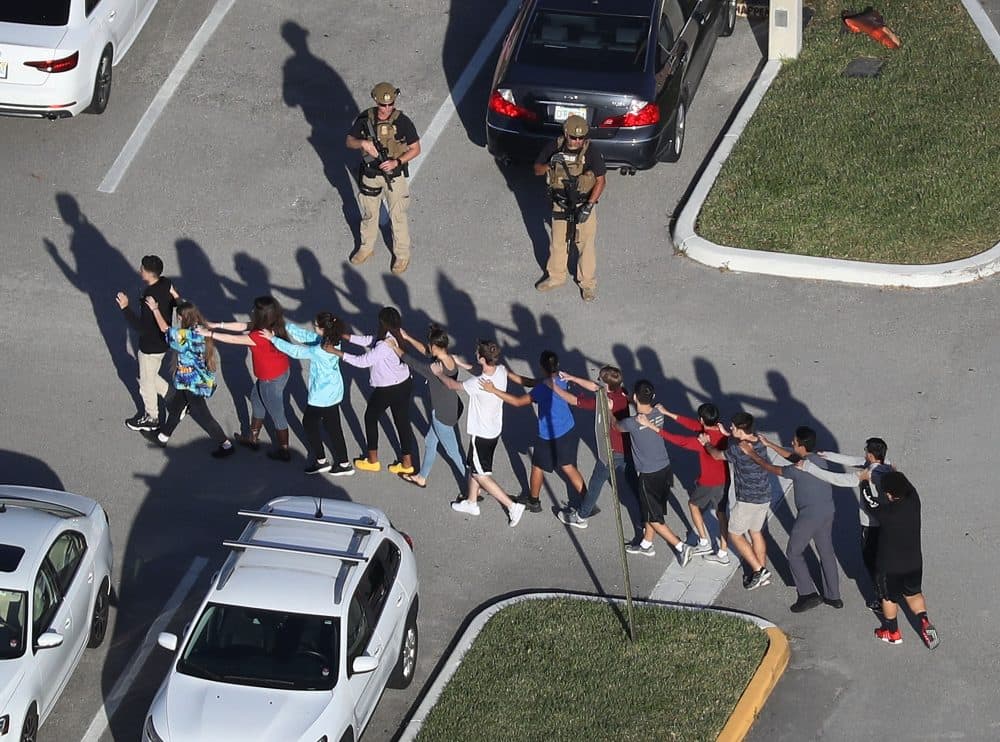 People are brought out of the Marjory Stoneman Douglas High School after a shooting on Feb. 14, 2018 in Parkland, Fla. President Trump's reference to the school resource officer who remained outside during the shooting as a "coward" sparked a national conversation about cowardice. (Joe Raedle/Getty Images)