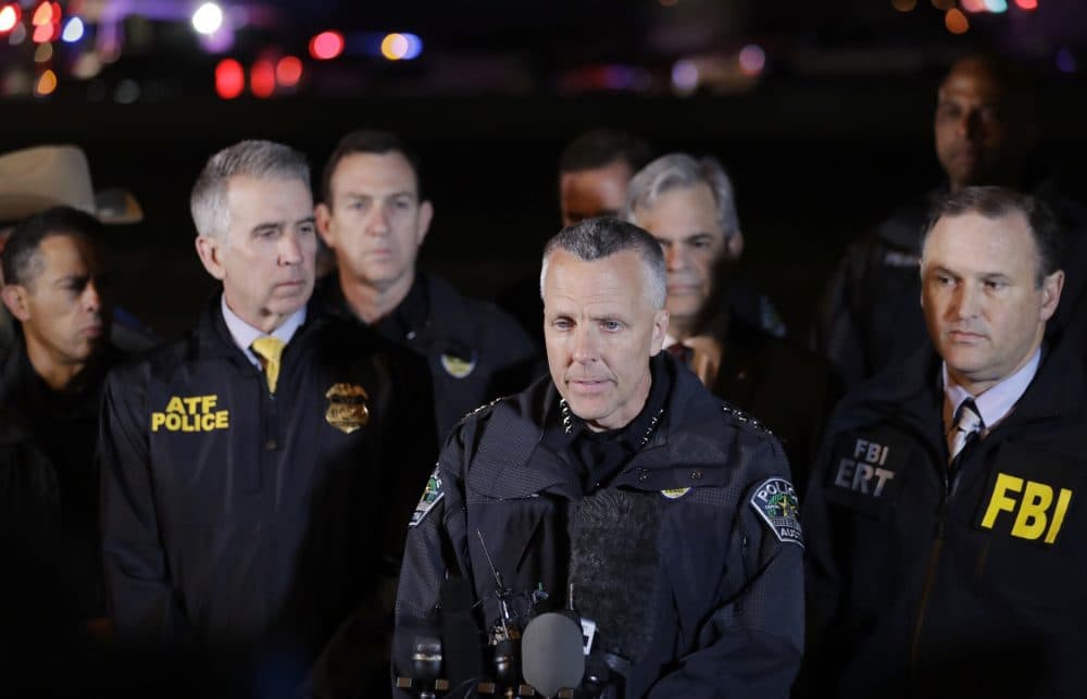 Austin Police Chief Brian Manley, center, stands with other members of law enforcement as he briefs the media, Wednesday, March 21, 2018, in the Austin suburb of Round Rock, Texas. The apparent suspect in a spate of bombing attacks that have terrorized Austin over the past month blew himself up with an explosive device as authorities closed in, the police said early Wednesday. (AP Photo/Eric Gay)