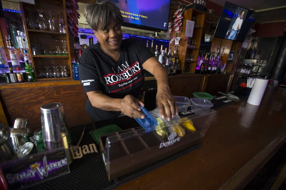 Andrea Walker preps the bar at Sonny Walker's before opening. (Jesse Costa/WBUR)