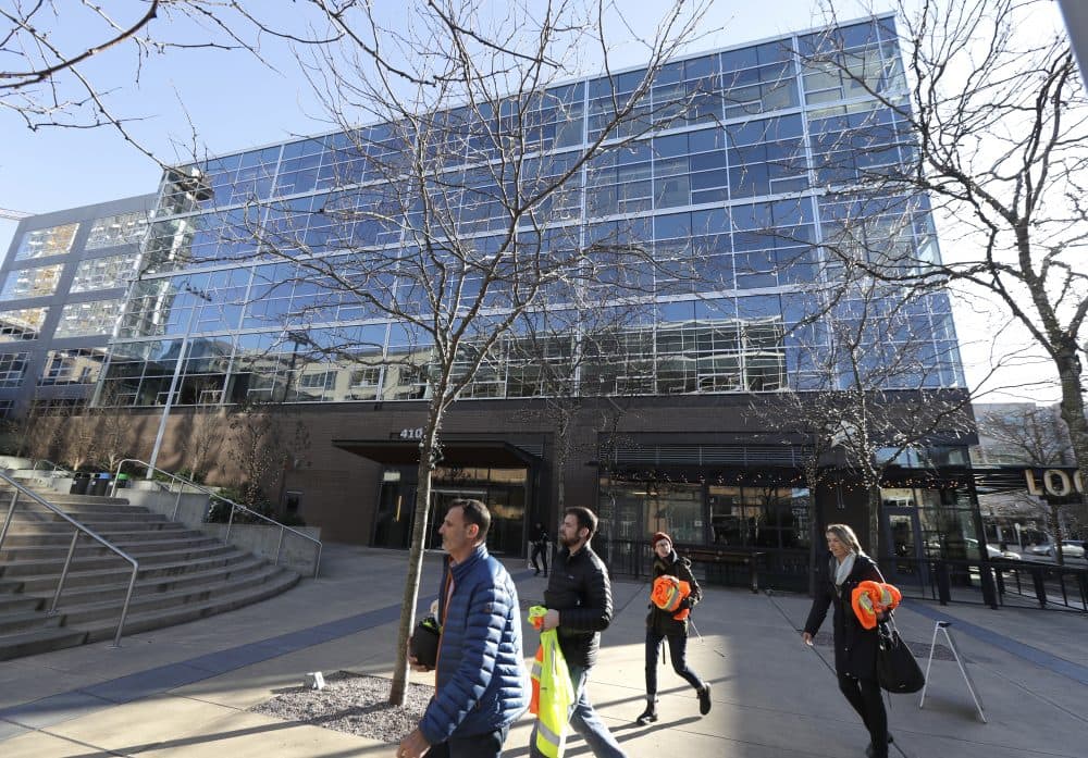 Pedestrians walk outside a building at Amazon.com's corporate headquarters in Seattle. (Ted S. Warren/AP)