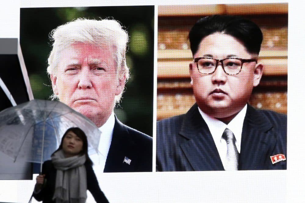 A woman walks by a huge screen showing U.S. President Donald Trump, left, and North Korea's leader Kim Jong Un, in Tokyo, Friday, March 9, 2018. After a year of threats and diatribes, U.S. President Donald Trump and third-generation North Korean dictator Kim Jong Un have agreed to meet face-to-face for talks about the Norths nuclear program.(AP Photo/Koji Sasahara)