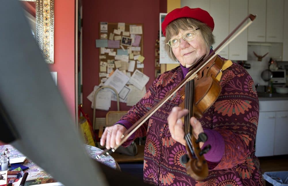 Betty Hauck, a musician suffering from hearing loss, plays her viola at home in Cambridge, Mass. (Robin Lubbock/WBUR)
