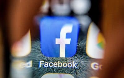 The icon for the social networking app Facebook on a smartphone screen, photographed through a magnifying glass. (Mladen Antonov/AFP/Getty Images)