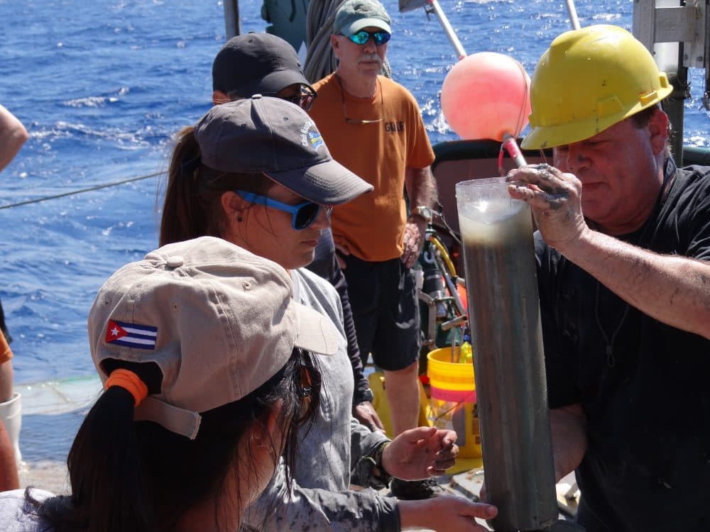 Marine geologist David Hollander (USF, right) instructs Cuban students on sediment core sampling techniques off northwest Cuba. Dr. Greg Brooks (Eckerd College, orange shirt) assists. (Courtesy of C-IMAGE)