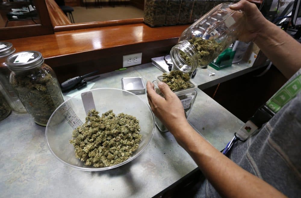 In 2016, an employee places marijuana for sale into containers at The Station, a retail and medical cannabis dispensary in Boulder, Colorado. (Brennan Linsley/AP)