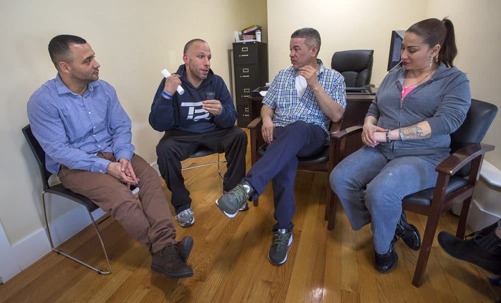 From left to right: Felito Diaz, Julio Cesar Santiago, Richard Lopez and Irma Bermudez speak at Casa Esperanza, a collection of day treatment, residential programs and transitional housing in Roxbury. (Jesse Costa/WBUR)