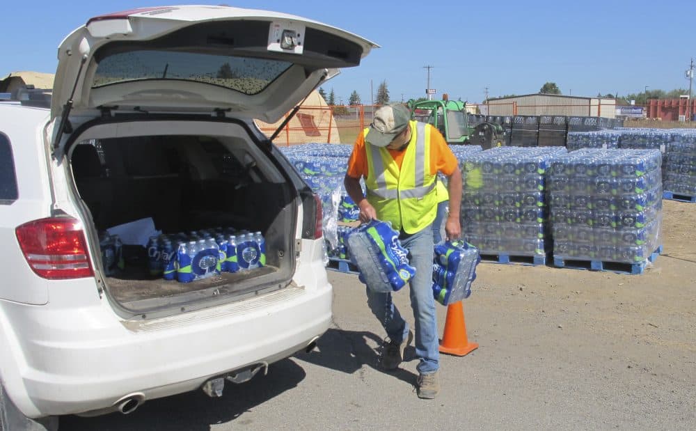 In this photo taken June 5, 2017, a U.S. Air Force worker loads bottled water into a vehicle in Airway Heights, Wash. Tests near Fairchild Air Force Base found groundwater tainted with two industrial chemicals used for years in firefighting foam and consumer products such as nonstick cookware. (Nicholas K. Geranios/AP)
