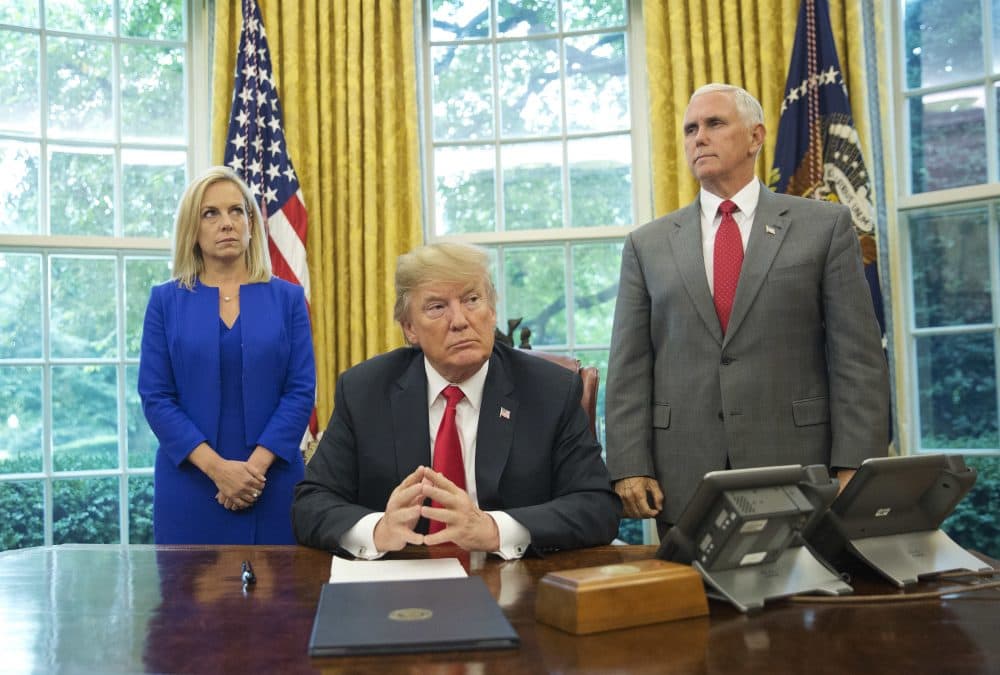 President Donald Trump, center, with Homeland Security Secretary Kirstjen Nielsen, left, and Vice President Mike Pence, right, before signing an executive order to end family separations, during an event in the Oval Office of the White House in Washington, Wednesday, June 20, 2018. (Pablo Martinez Monsivais/AP)