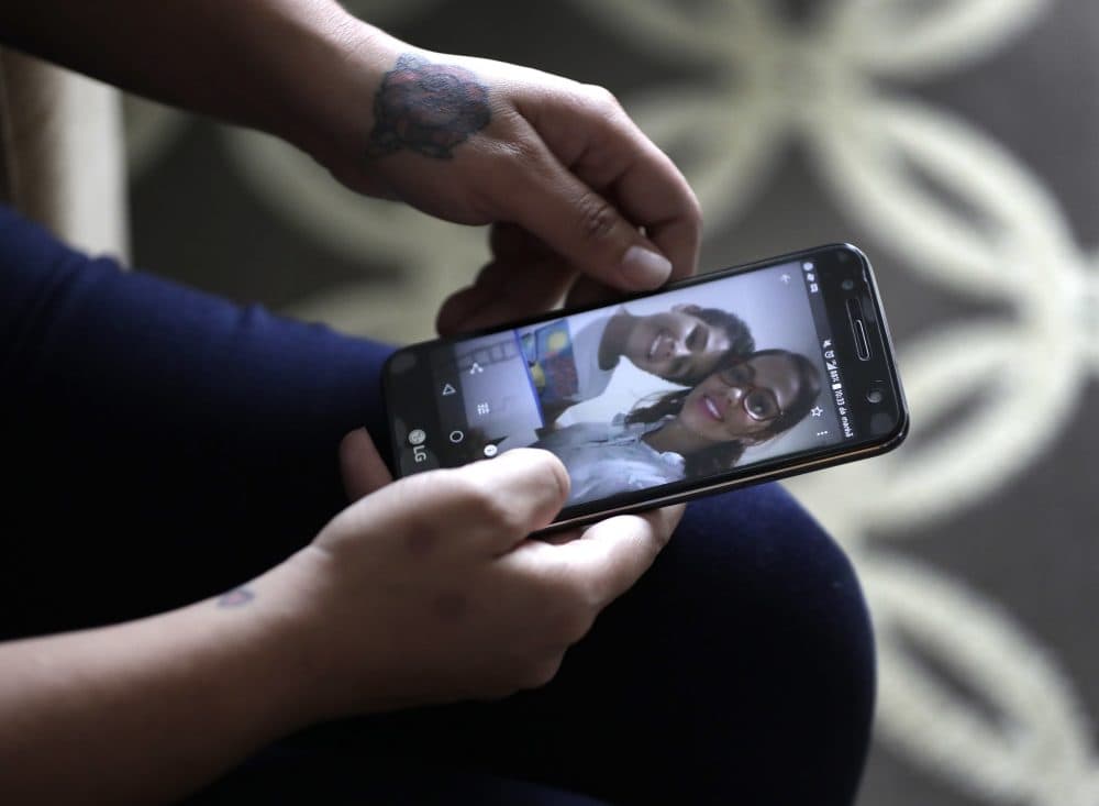 Lidia Karine Souza, who is seeking asylum from Brazil, flips through photographs of her and her son Diogo. (Charles Rex Arbogast/AP)