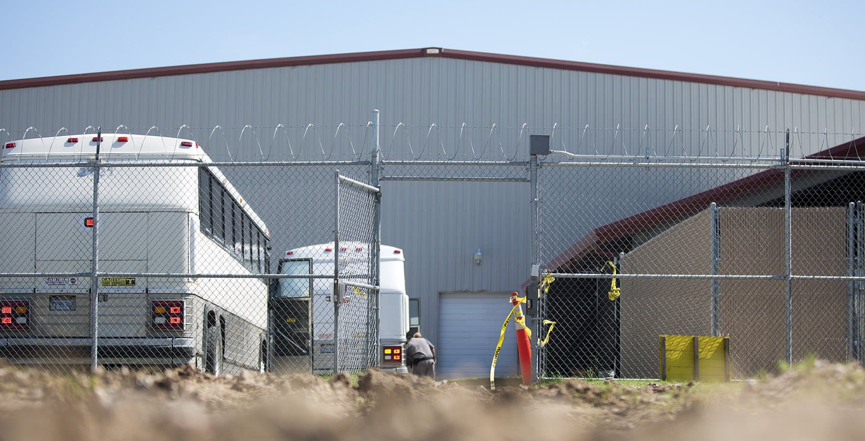 Buses are prepared by border patrol officers at the Centralized Processing Center in McAllen, Texas, for unauthorized immigrants to be transported and held at longer-term facilities. (Jesse Costa/WBUR)